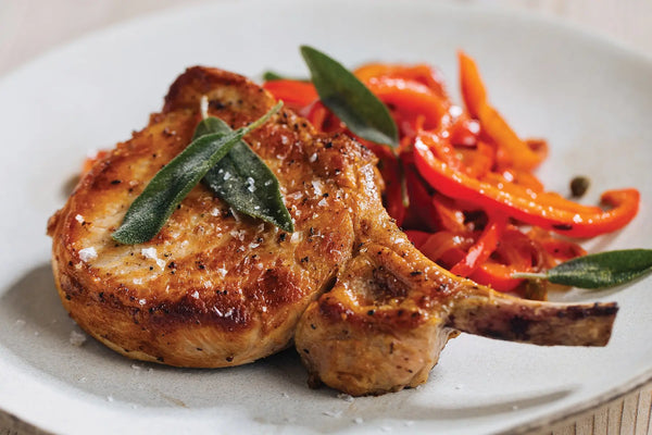 Seared Thick-Cut Bone-In Pork Chop with Peperonata Sauce and Crispy Sage